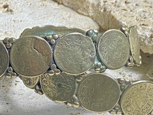 Antique silver cuffs consist of Indian half rupee coins welded to an inner cuff of silver. Two coins date to 1918, and are 91.7% silver. Older or younger coins vary but all half rupees contain min 50% silver. The cuffs are rigid and can only be altered slightly. Inside width 8 cm, height 1.8 cm.