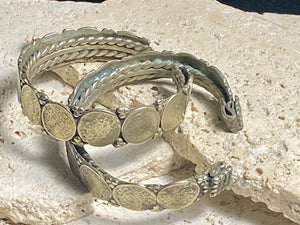 Antique silver cuffs consist of Indian half rupee coins welded to an inner cuff of silver. Two coins date to 1918, and are 91.7% silver. Older or younger coins vary but all half rupees contain min 50% silver. The cuffs are rigid and can only be altered slightly. Inside width 8 cm, height 1.8 cm.