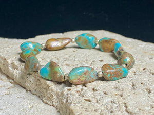 Natural Tibetan turquoise bracelet finished with sterling silver beads. Strong on sturdy elastic for a seamless look. Measurements: length 19 cm (7.5")
