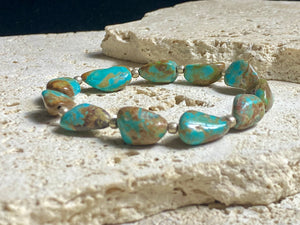 Natural Tibetan turquoise bracelet finished with sterling silver beads. Strong on sturdy elastic for a seamless look. Measurements: length 19 cm (7.5")
