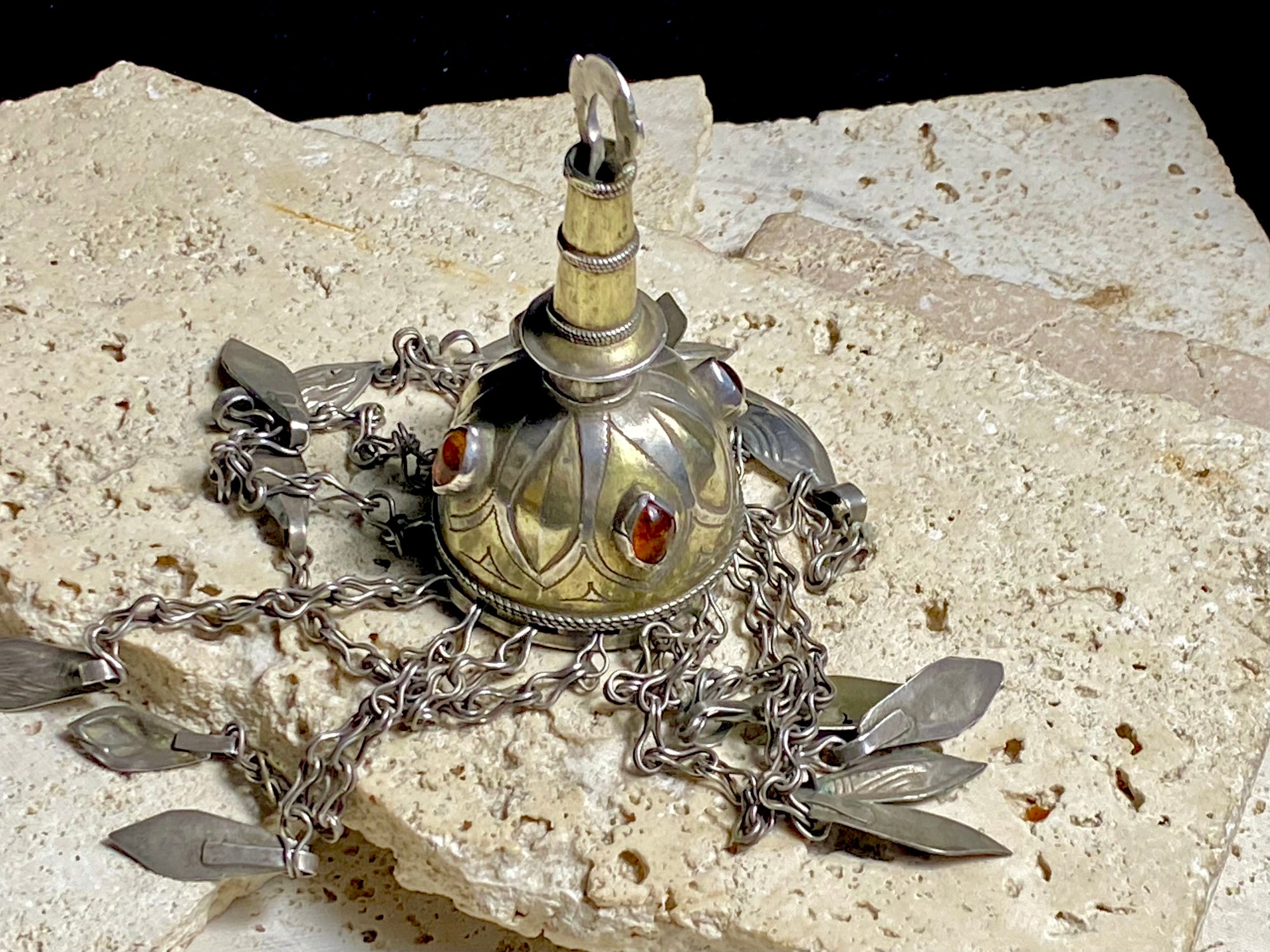 Tekke Turkoman women's cap jewellery.&nbsp; High grade silver, 24k gold fire gilding, finished with four carnelian stones.All dangles are intact. Mid 20th Century. This would have once endowed the headdress of a Turkoman girl. Measurements: total height including dangles 18 cm (6.5"). Diameter at base 5 cm (1.5"). Height of body (without dangles) 8.5 cm