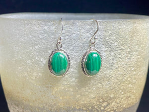 These stunning, classic oval earrings feature high quality, large cabochon cut oval malachite stones set in a beautifully detailed sterling silver bezel. Measurements: 3.5 cm(1.35”) length including hook