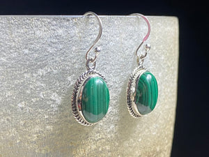 These stunning, classic oval earrings feature high quality, large cabochon cut oval malachite stones set in a beautifully detailed sterling silver bezel. Measurements: 3.5 cm(1.35”) length including hook