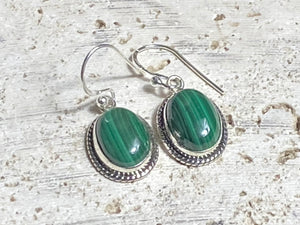 These stunning, classic oval earrings feature high quality, large cabochon cut oval malachite stones set in a beautifully detailed sterling silver bezel. Measurements: 3.5 cm(1.35”) length including hook