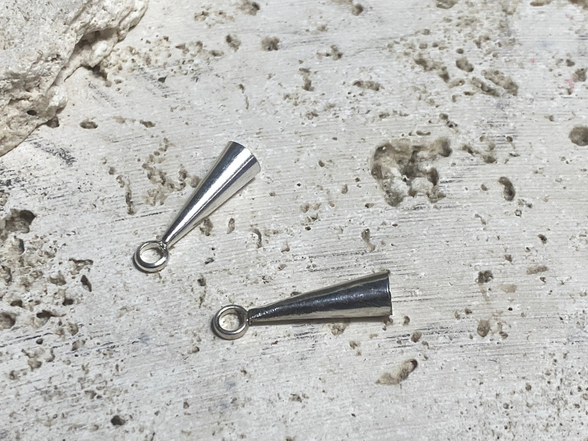 Strong and long elegant silver cone ends. Perfect for finishing multi strand necklaces. Long enough to hold single tapered stones with absolute confidence. Lght enough to be incorporated into earring projects.Sterling silver. Length 2.2 cm
