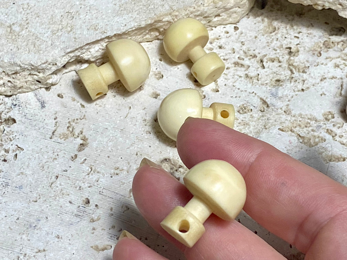 Large domed bone buttons, hand carved from buffalo bone. From Burma. Length 22 cm, diameter1.6 cm