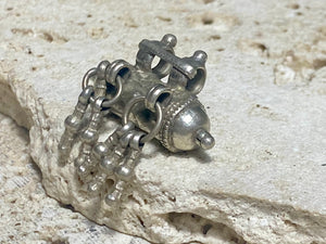 High grade silver amulet with fused ends, early 20th century, from northern India. The decoration is unusual, with a bar connecting the bails and a set of silver dangles fused together. Measurements: length 3.1 cm, diameter 1.5 cm, height including dangles 3 cm