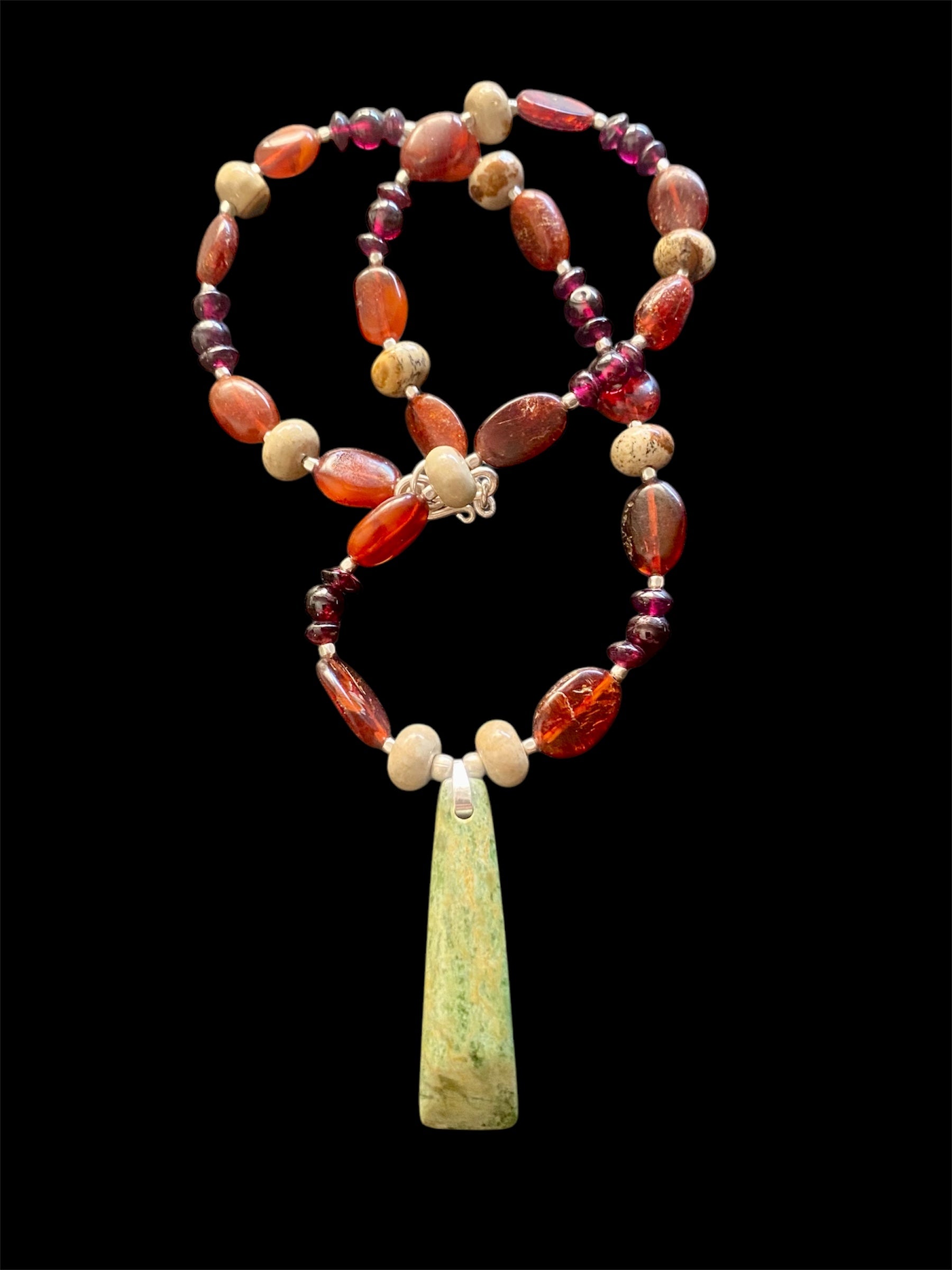 Statement necklace features a jade pendant with jasper, buffalo horn and red garnet beads, highlighted with silver beads & clasp. Length 47.5 cm, pendant 4.6 cm