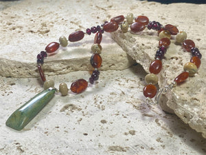 Statement necklace features a jade pendant with jasper, buffalo horn and red garnet beads, highlighted with silver beads & clasp. Length 47.5 cm, pendant 4.6 cm