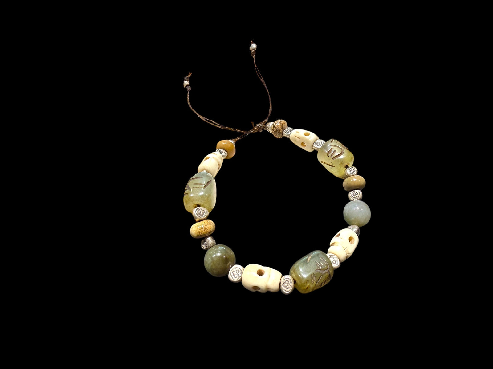 Heavy bracelet of carved yak bone, jasper, vintage Tibetan jade and Karen hill tribe silver. On waxed cord, adjustable, unisex. Length 18.5 cm, size 17 cm