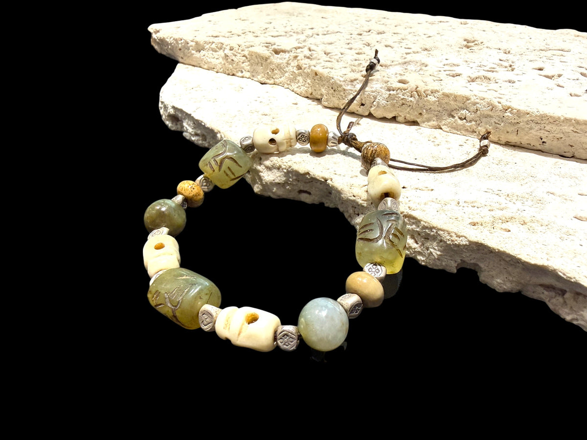 Heavy bracelet of carved yak bone, jasper, vintage Tibetan jade and Karen hill tribe silver. On waxed cord, adjustable, unisex. Length 18.5 cm, size 17 cm