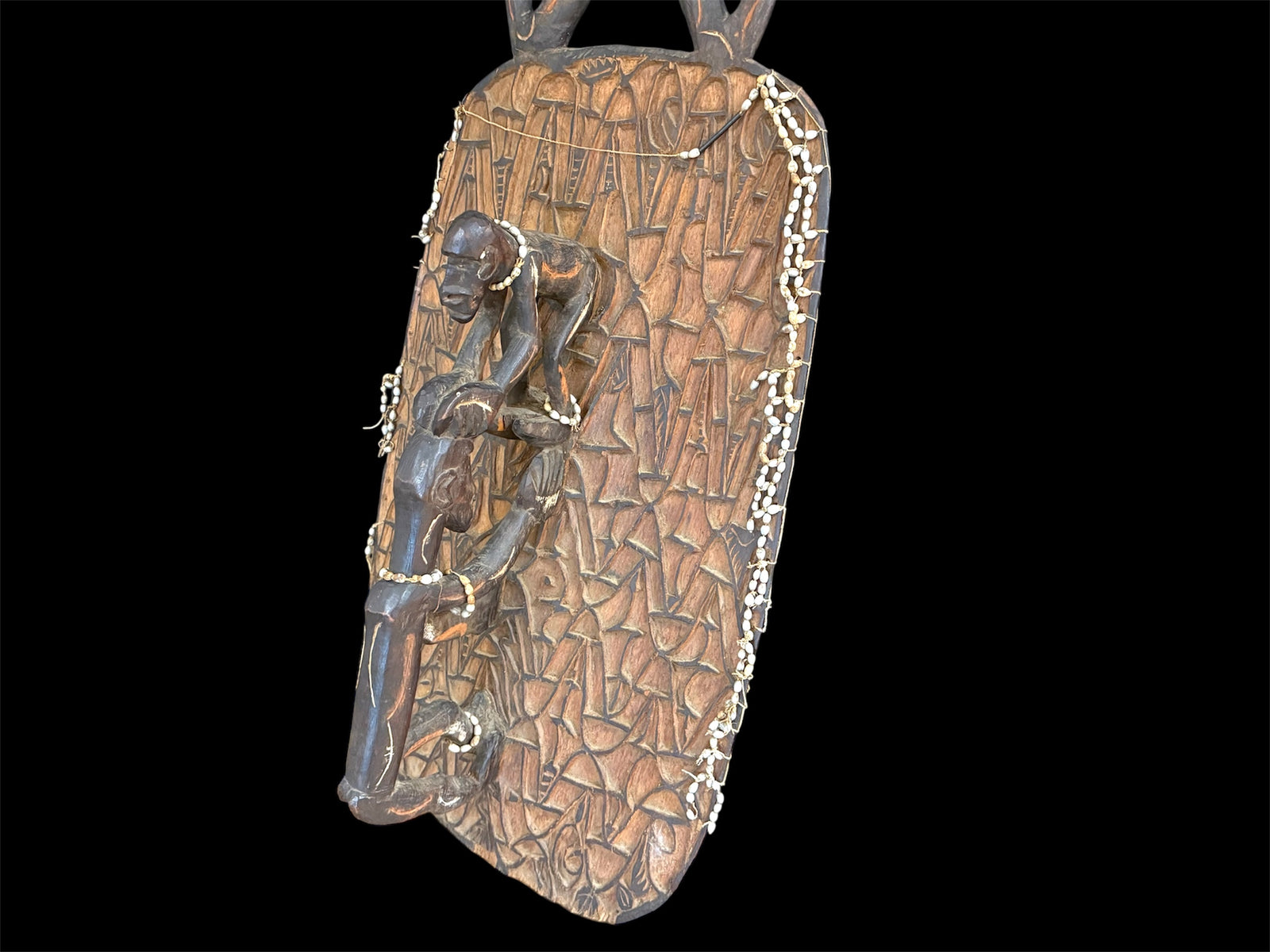 Asmat jungle hardwood shield. Wood carved and decorated with lime, ochre, charcoal, and shell beading. Central Asmat region, Irian Jaya (Indonesian Papua). Measurements: 104 cm x 39 cm, depth 17 cm