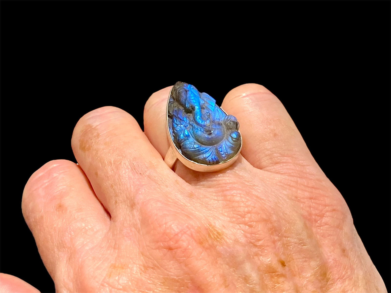 Hand carved labradorite ring with excellent fire featuring Ganesh. Sterling silver. A high quality stone with excellent colour. Stone 3 cm. Size 6.5
