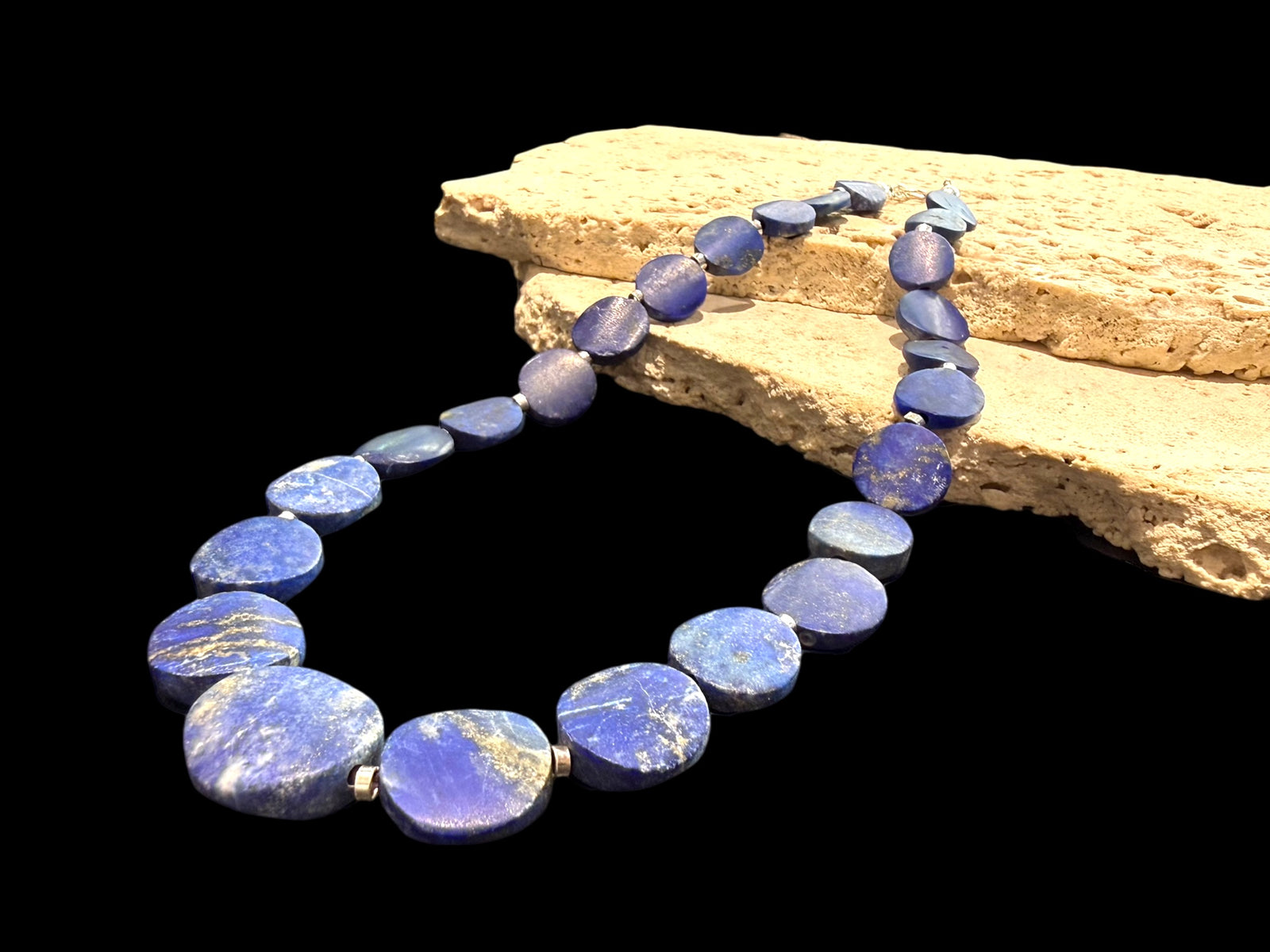 Natural lapis lazuli flat disk beads, colour matched and graduated, with sterling silver spacer beads and a sterling silver clasp. Length 43 cm