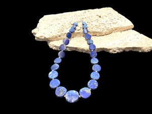Natural lapis lazuli flat disk beads, colour matched and graduated, with sterling silver spacer beads and a sterling silver clasp. Length 43 cm