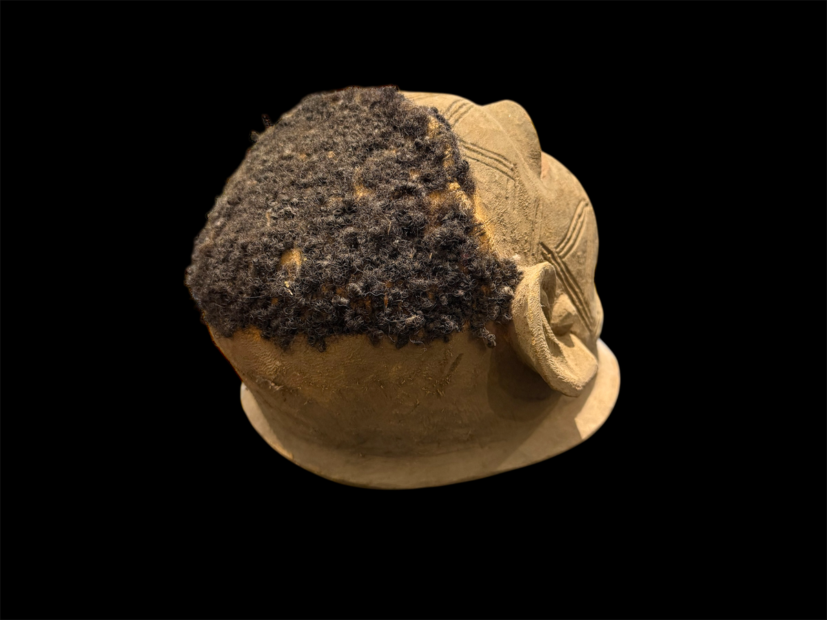 Makonde helmet mask. Balsa wood, human hair and pigment. Moda, Mozambique. Circa mid 90's. Worn in dances that conclude the initiation ceremonies for adolescent boys and girls. Measurements: length 24 cm, width 20 cm, height 22 cm