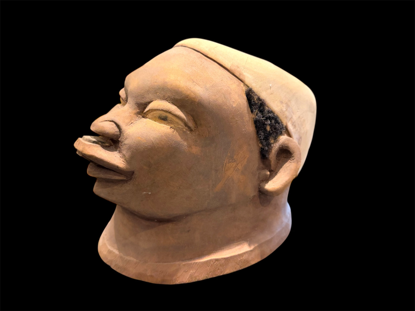 Makonde helmet mask. Balsa wood, human hair and pigment. Moda, Mozambique, Circa mid 90's. Worn in dances that conclude the initiation ceremonies for adolescent boys and girls. Measurements: length 25 cm, width 19 cm, height 20 cm