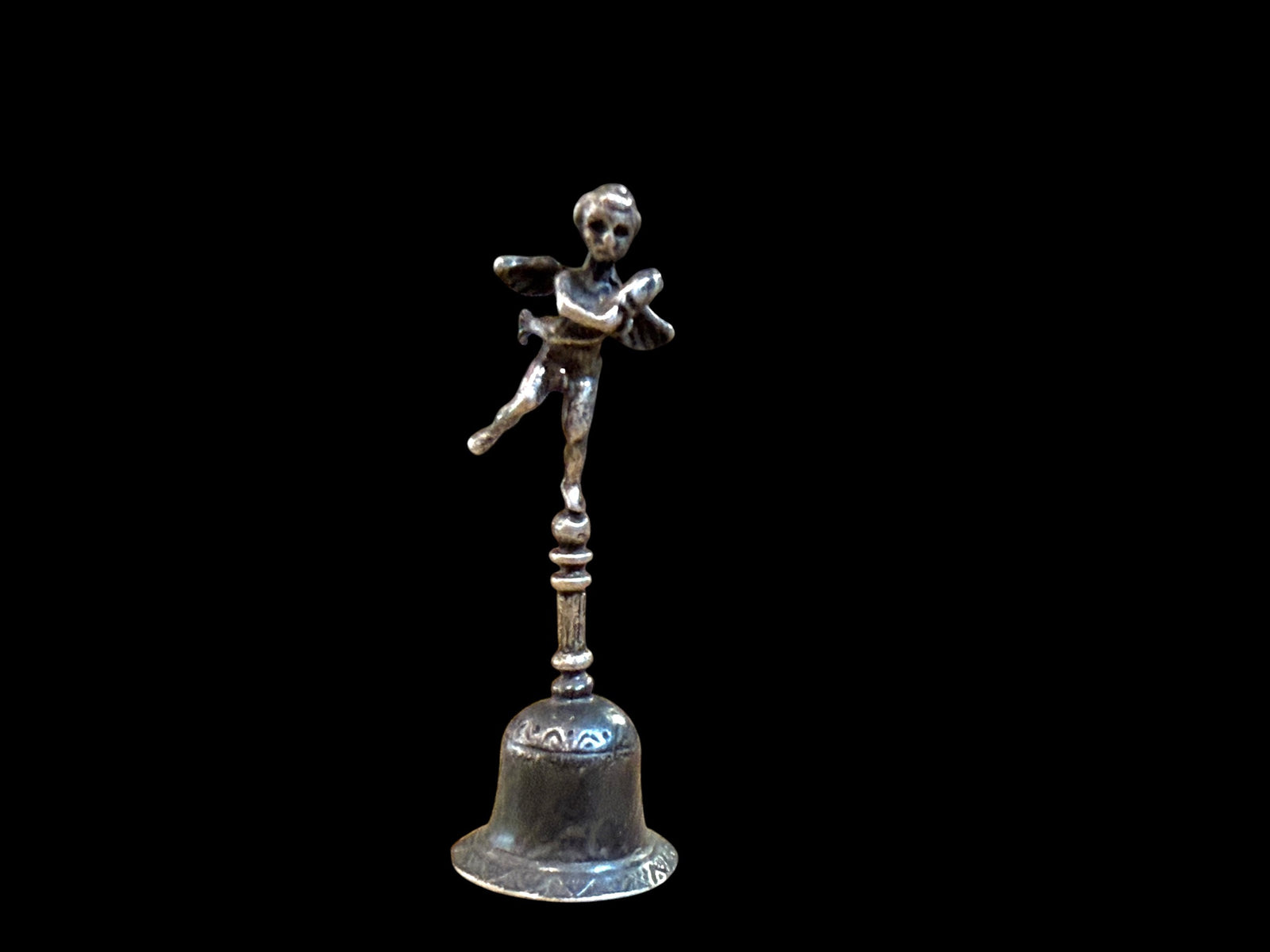 Small, decorative vintage bell with winged putto and dolphin. Sweet tone. Marked 800 ie 80% silver. From Italy. Height 6.4 cm. Diameter of bell's base 2.2 cm.
