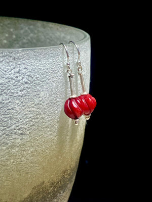 A simple earring featuring a hand carved red coral bead and sterling silver handmade Indian beads with silver hooks. Light and easy to wear, and a petite, classic earring. Measurements: 3 cm length including hook