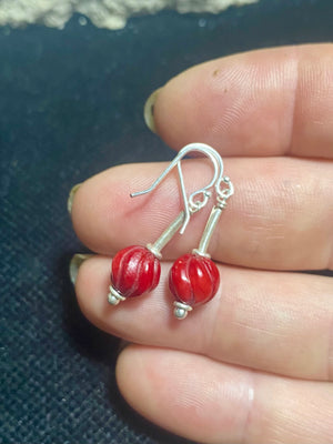 A simple earring featuring a hand carved red coral bead and sterling silver handmade Indian beads with silver hooks. Light and easy to wear, and a petite, classic earring. Measurements: 3 cm length including hook