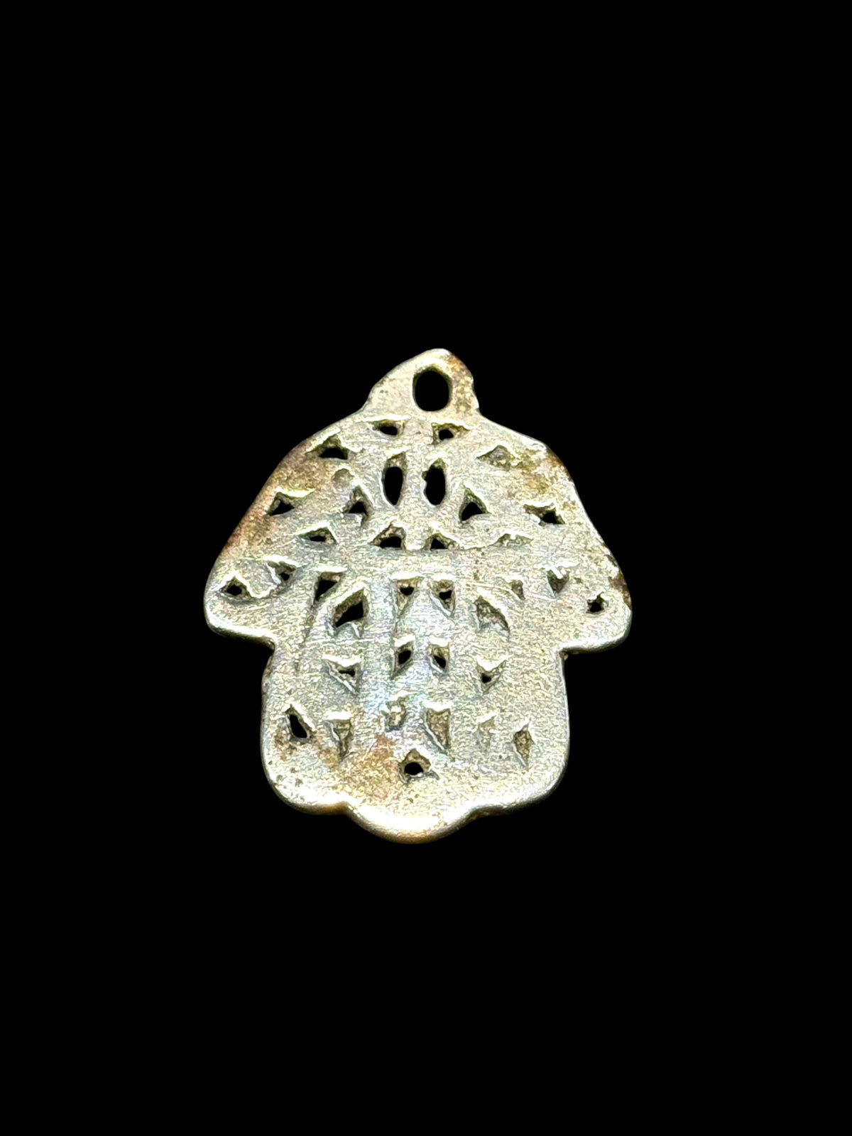 Antique Tunisian silver hamsa amulet pendant. Cast openwork decoration, rounded outline, softened detail consistent with wear. Height 3.5 cm, width 2.6 cm