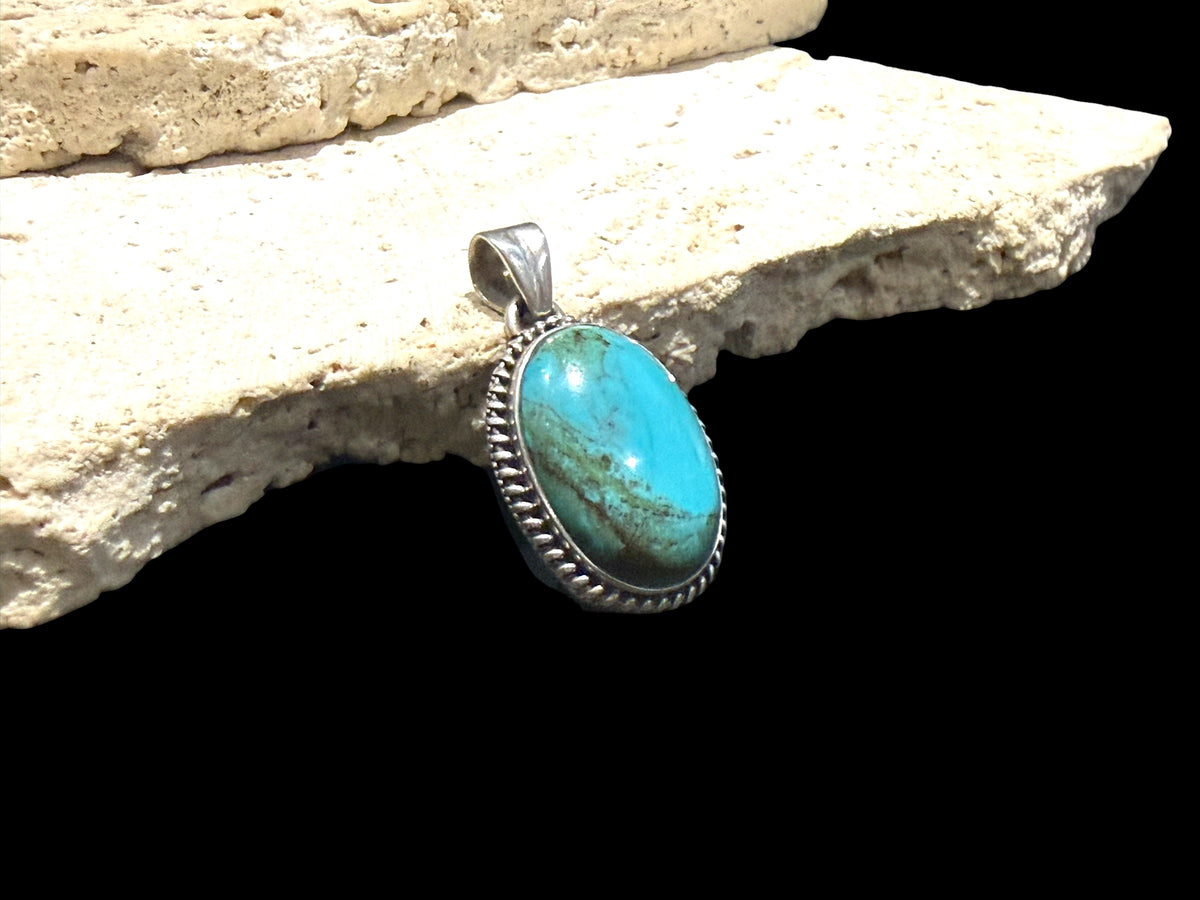 Large oval turquoise pendant is set off by a twist-rope sterling silver bezel, Measurements: 4 cm height including bail