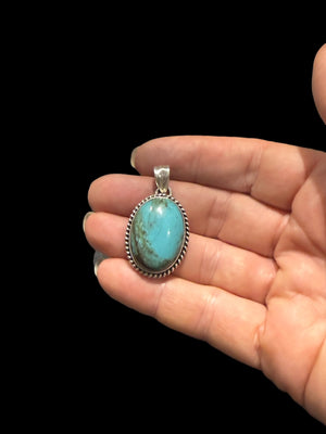 Large oval turquoise pendant is set off by a twist-rope sterling silver bezel, Measurements: 4 cm height including bail