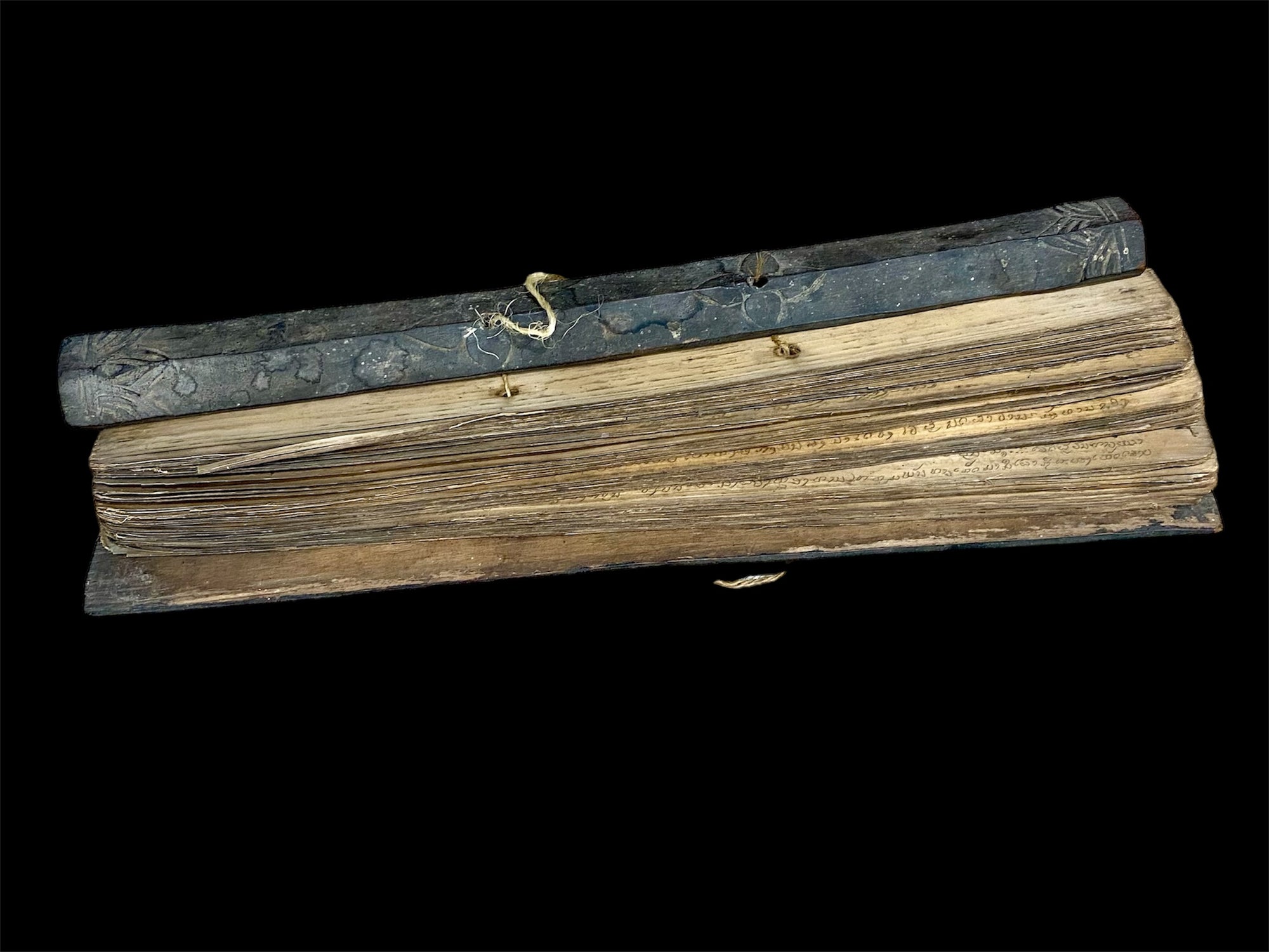 Sinhalese palm (ola) leaf book, ca. early 20th century CE. South Asia. Religious text from a Hindu-Buddhist monastery. Contains 60 leaves bound by two cords between a pair of wood slat covers. Measurements: Length 56 cm (22") x height 7.5 cm (3") x width 4.5 cm (1.75")