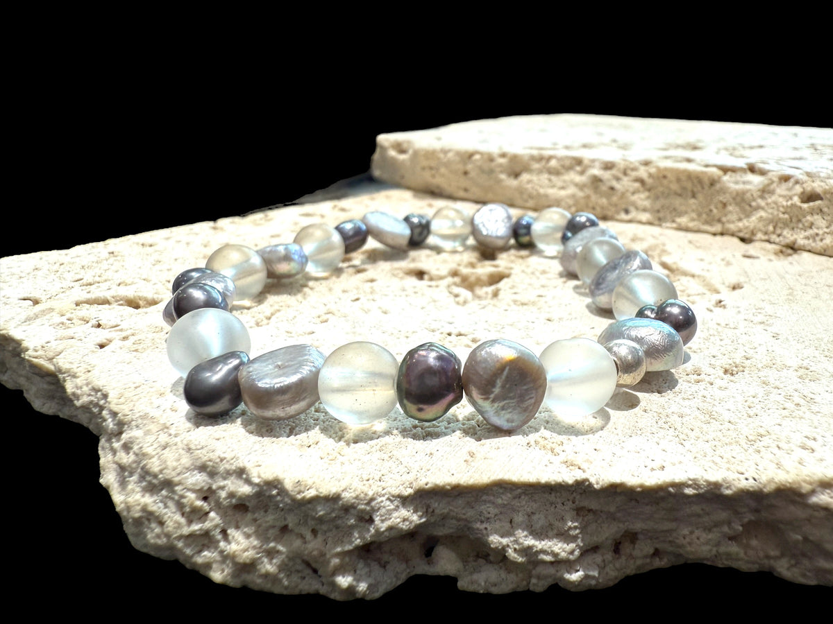 A delightful bracelet of irregular silver and dark grey freshwater pearls, rock crystal beads and sterling silver. Elasticised stringing for a seamless look.