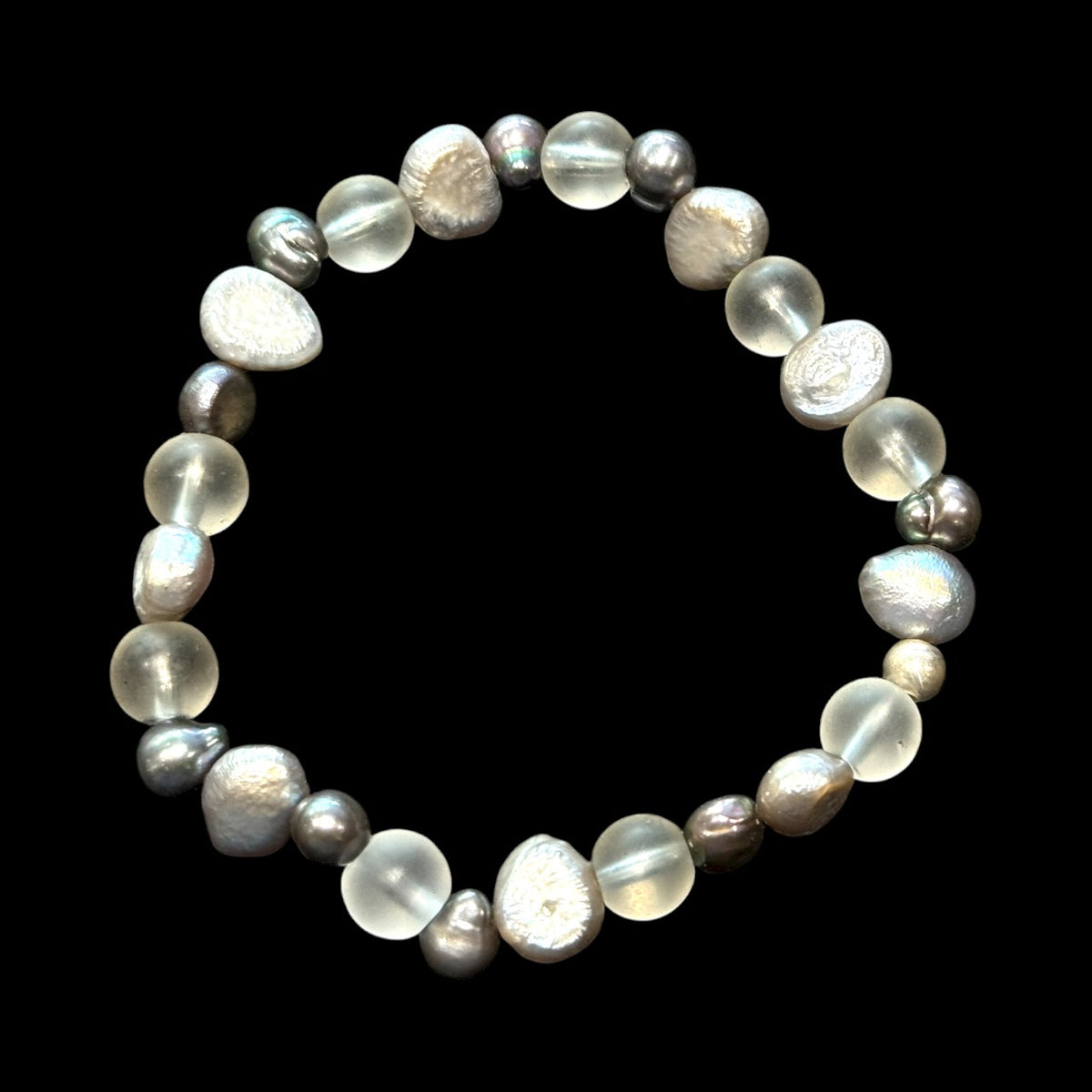 A delightful bracelet of irregular silver and dark grey freshwater pearls, rock crystal beads and sterling silver. Elasticised stringing for a seamless look.