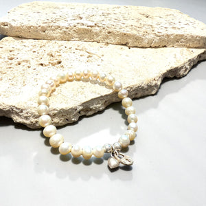 Freshwater pearl bracelet with sterling silver bead & charm detailing. Elasticised stringing for a seamless look.

Measurements: wrist circumference 16 - 17 cm.