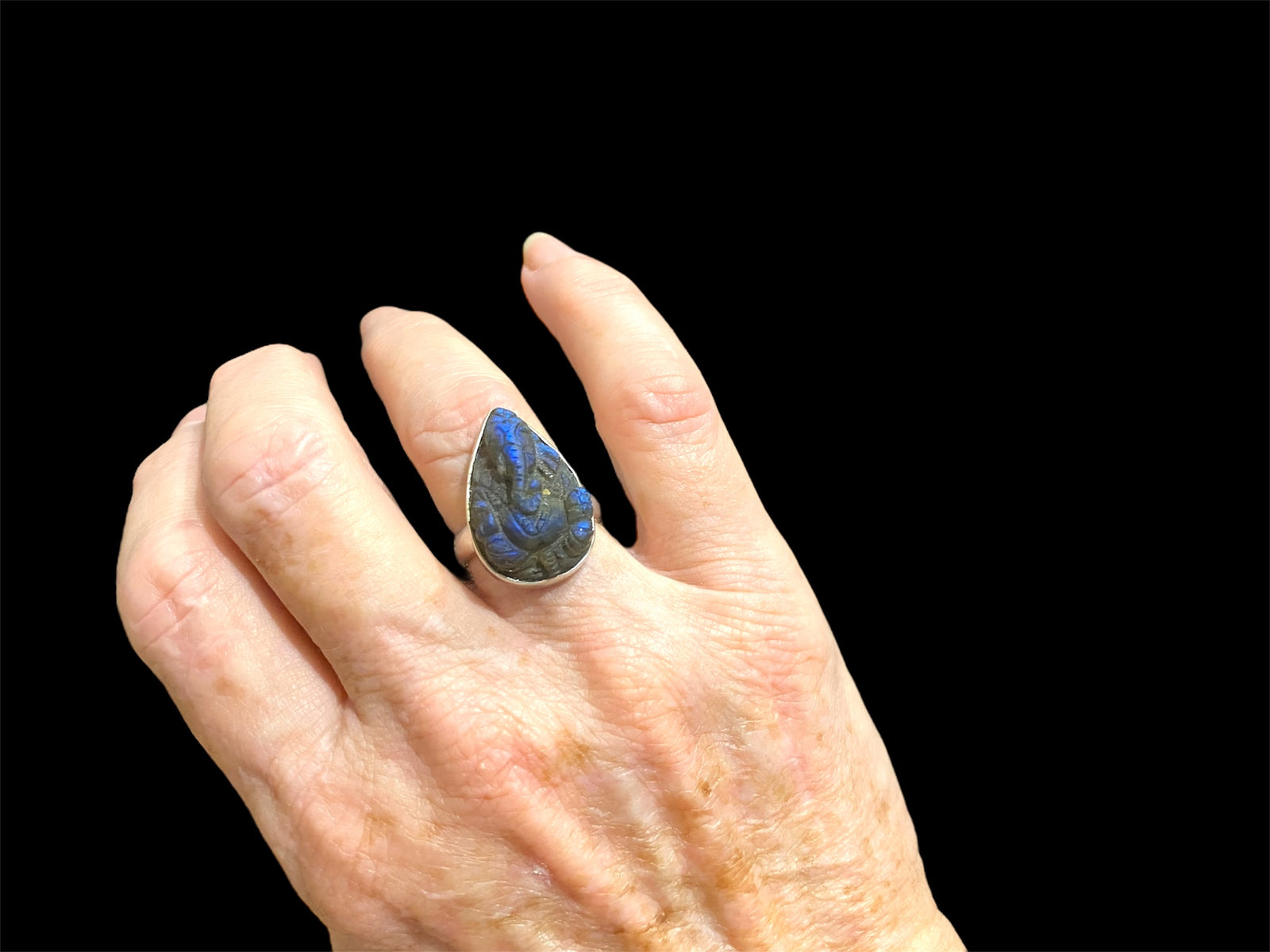 Very dark, hand carved labradorite ring with deep fire featuring Ganesh. Sterling silver. Stone length 2.4 cm, width 1.5 cm, US Size 6.75 | 17.25 mm
