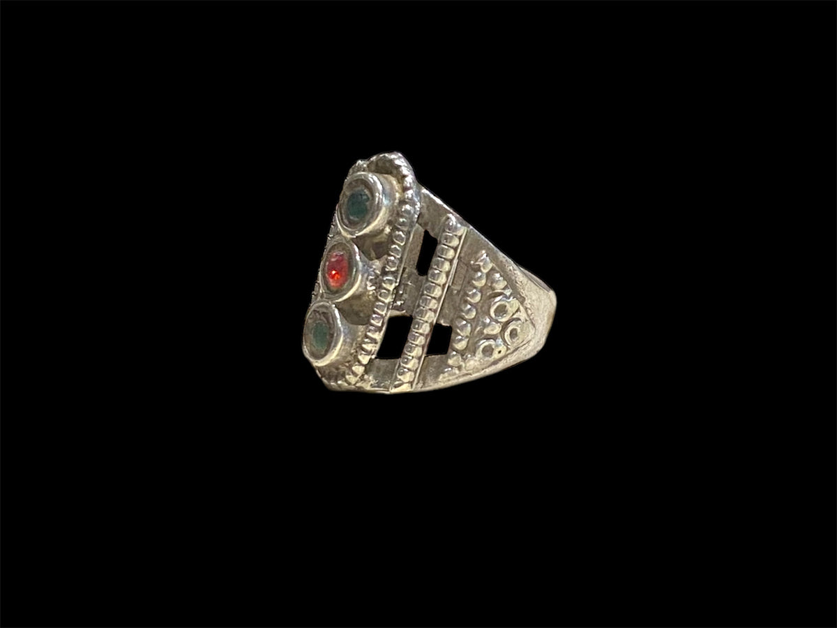 This unusual ring features three glass "gemstones" in a cutout design. High grade silver. Afghani, early 20th C. Face 2.5 cm height Sizing: 19.5 mm | Size 9.75