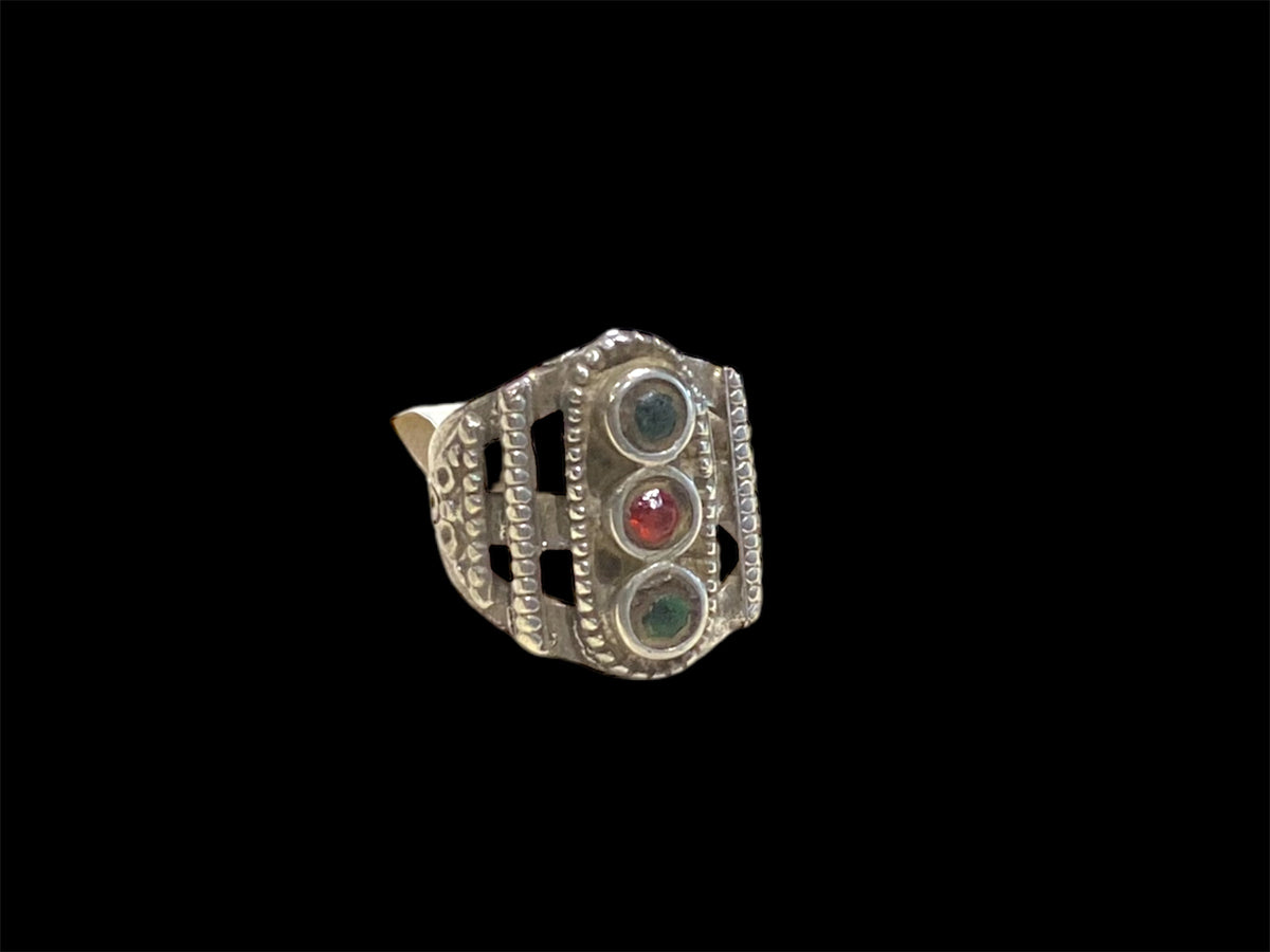 This unusual ring features three glass "gemstones" in a cutout design. High grade silver. Afghani, early 20th C. Face 2.5 cm height Sizing: 19.5 mm | Size 9.75