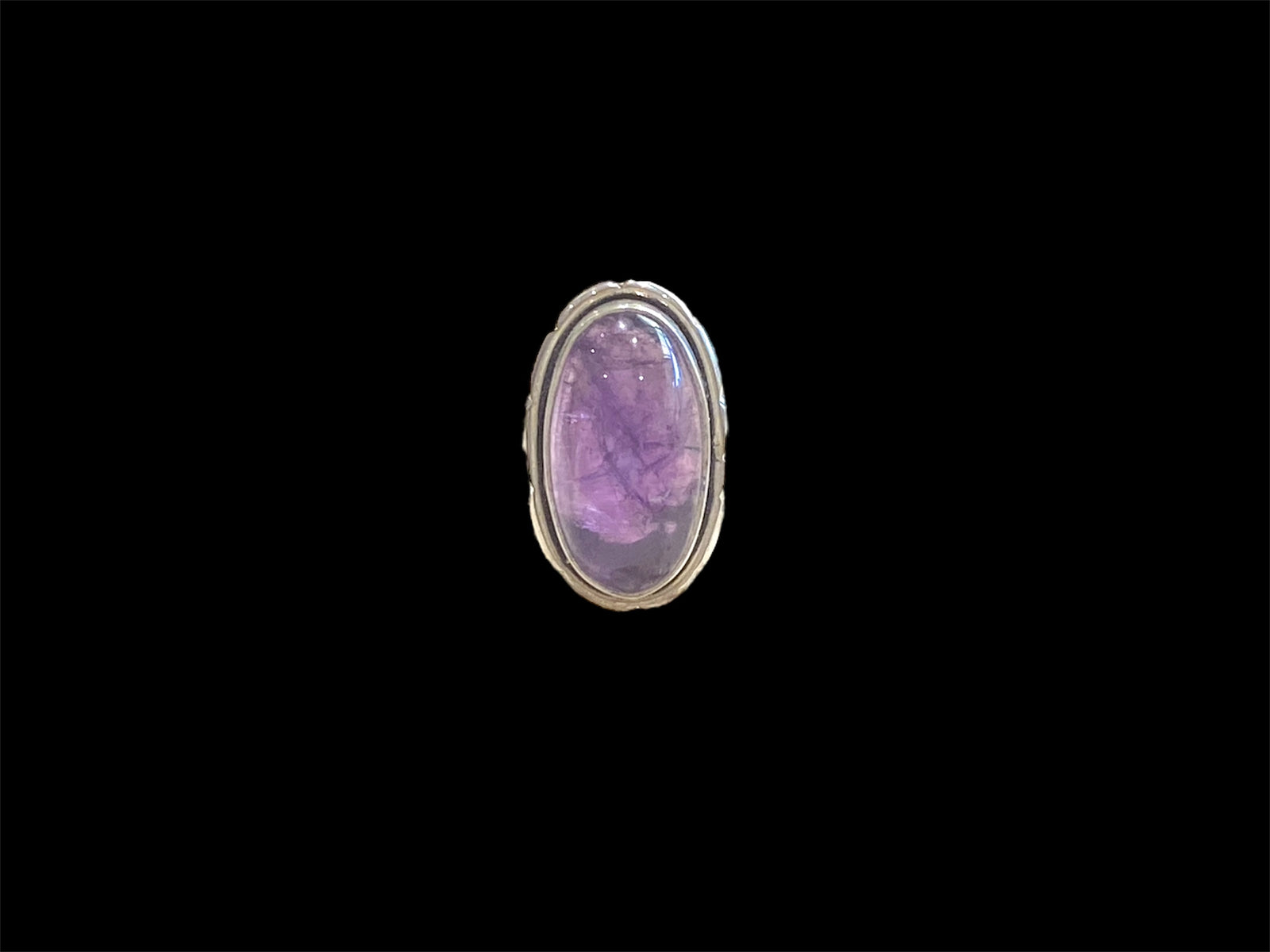 Elegant oval amethyst ring set in sterling silver. Open at the back to allow light to shine through, allowing the stone's natural beauty to shine through. Measurements: Face 2.4 x 1.4 cm Sizing: US Size 6 | 16.5 mm