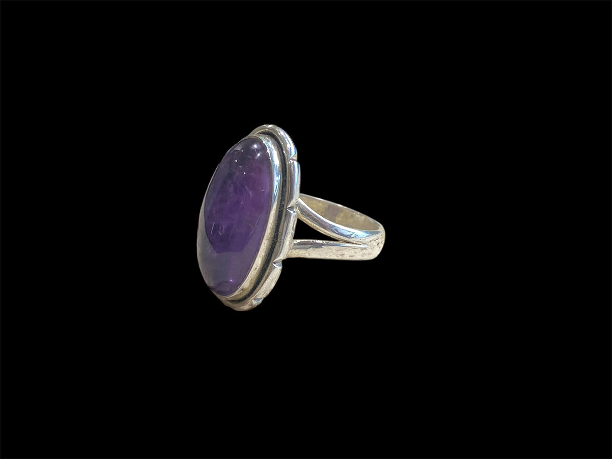 Elegant oval amethyst ring set in sterling silver. Open at the back to allow light to shine through, allowing the stone's natural beauty to shine through. Measurements: Face 2.4 x 1.4 cm Sizing: US Size 6 | 16.5 mm