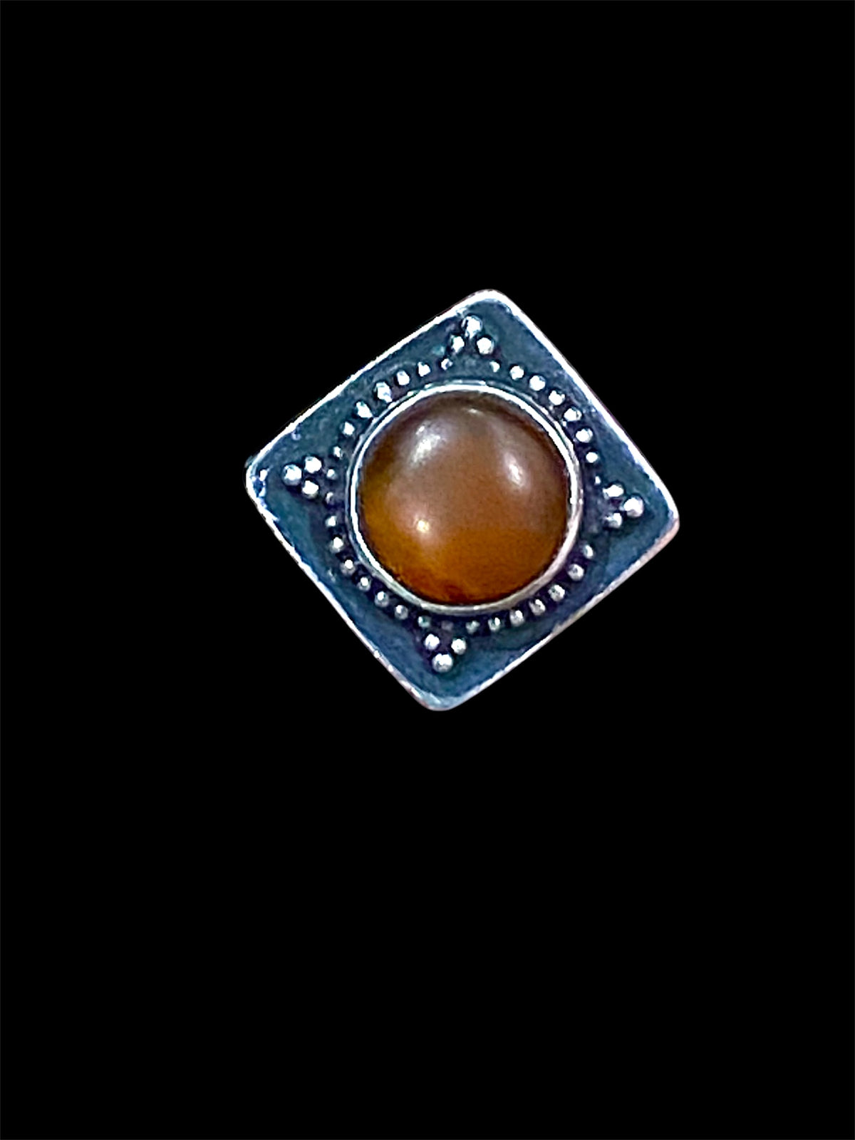 An unusual ring featuring a round carnelian stone set in a high box setting. Afghanistan, mid to late 20th century. Can be worn by either men or women. Measurements: Ring face 2.5 x 2.5, cm, height 1.5 cm. This is an adjustable ring spanning sizes 7 - 8
