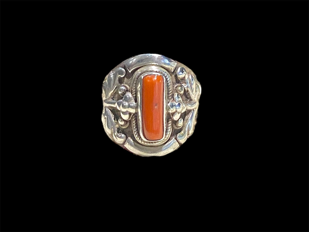 Beautifully detailed, petite ring set with a cabochon cut coral stone. Sterling silver. Handmade in Nepal. Measurements: Length of face 2 cm. Size 7.25 | 17.75 mm