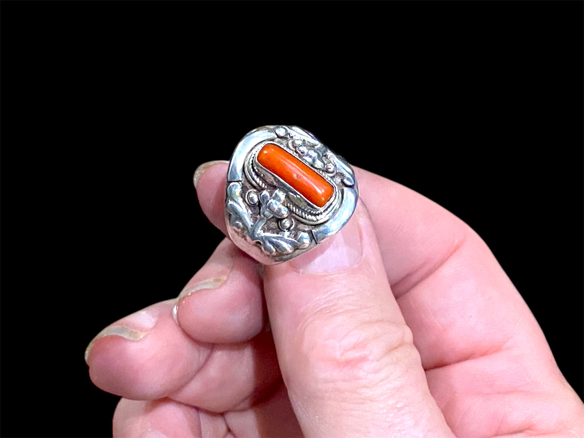 Beautifully detailed, petite ring set with a cabochon cut coral stone. Sterling silver. Handmade in Nepal. Measurements: Length of face 2 cm. Size 7.25 | 17.75 mm