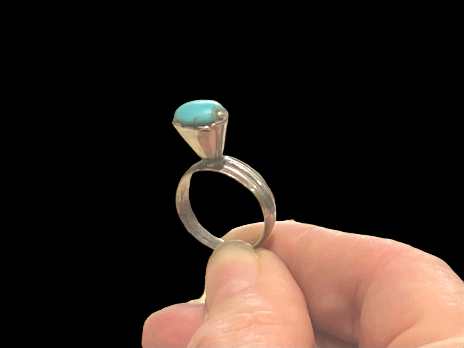 This unusual ring features an oval turquoise stone, set in a very high conical mount over a slender band. The turquoise stone is of excellent quality and contains very little matrix. Central Asia. Circa 1930. Stone 1 x 0.8 cm. Size 7 | 17.5 mm