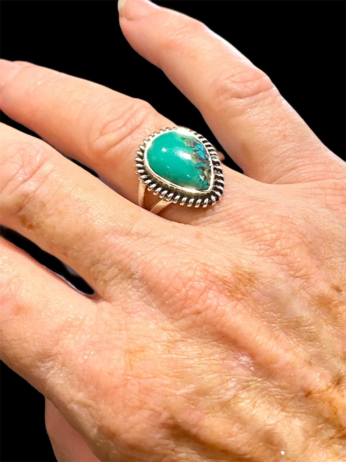 Teardrop turquoise ring featuring a high quality turquoise stone from Arizona, set in a decorated bezel. Can be worn by a man or a woman. Measurements: Stone and bezel 2 cm x 1.6 cm
Size 7.75 | 18 mm