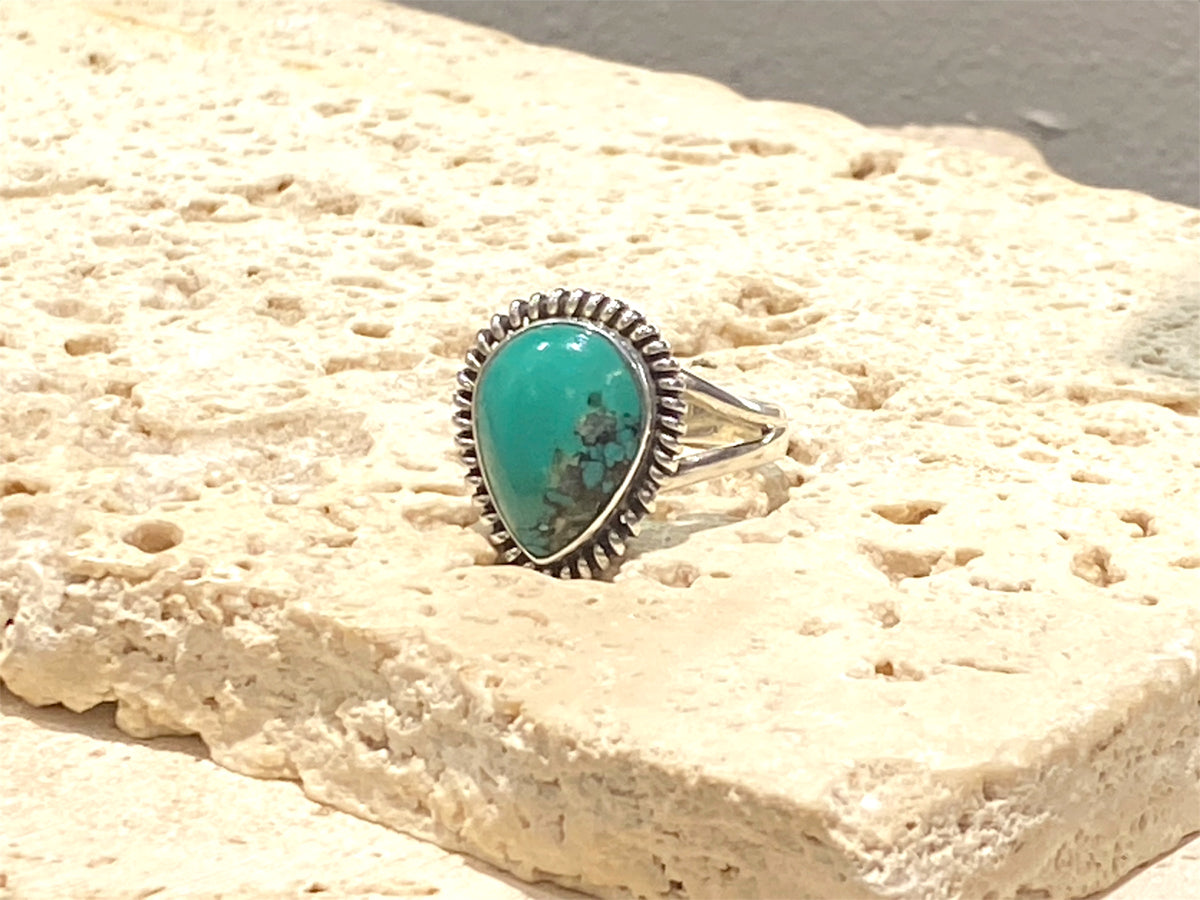 Teardrop turquoise ring featuring a high quality turquoise stone from Arizona, set in a decorated bezel. Can be worn by a man or a woman. Measurements: Stone and bezel 2 cm x 1.6 cm
Size 7.75 | 18 mm