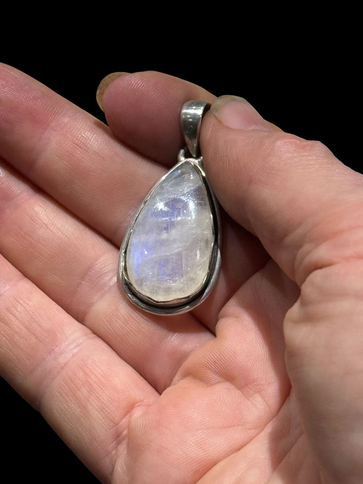 Teardrop rainbow moonstone pendant set in a scalloped sterling silver mount with a generous bail to take a large chain or cord. A lovely stone with blue colour and fire.&nbsp;

Measurements:&nbsp;Length including bail 4 cm, width at widest point 2 cm