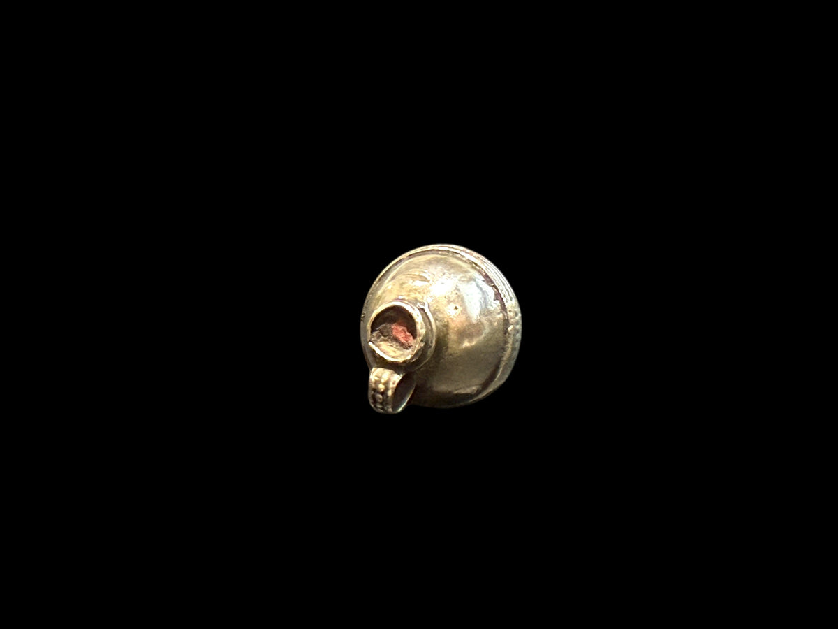 Unique tribal bead with two offset bails. Copper and silver, small glass bead set at one end. Early 20th C, northern India. Length 2.7 cm, diameter 1.7 cm.