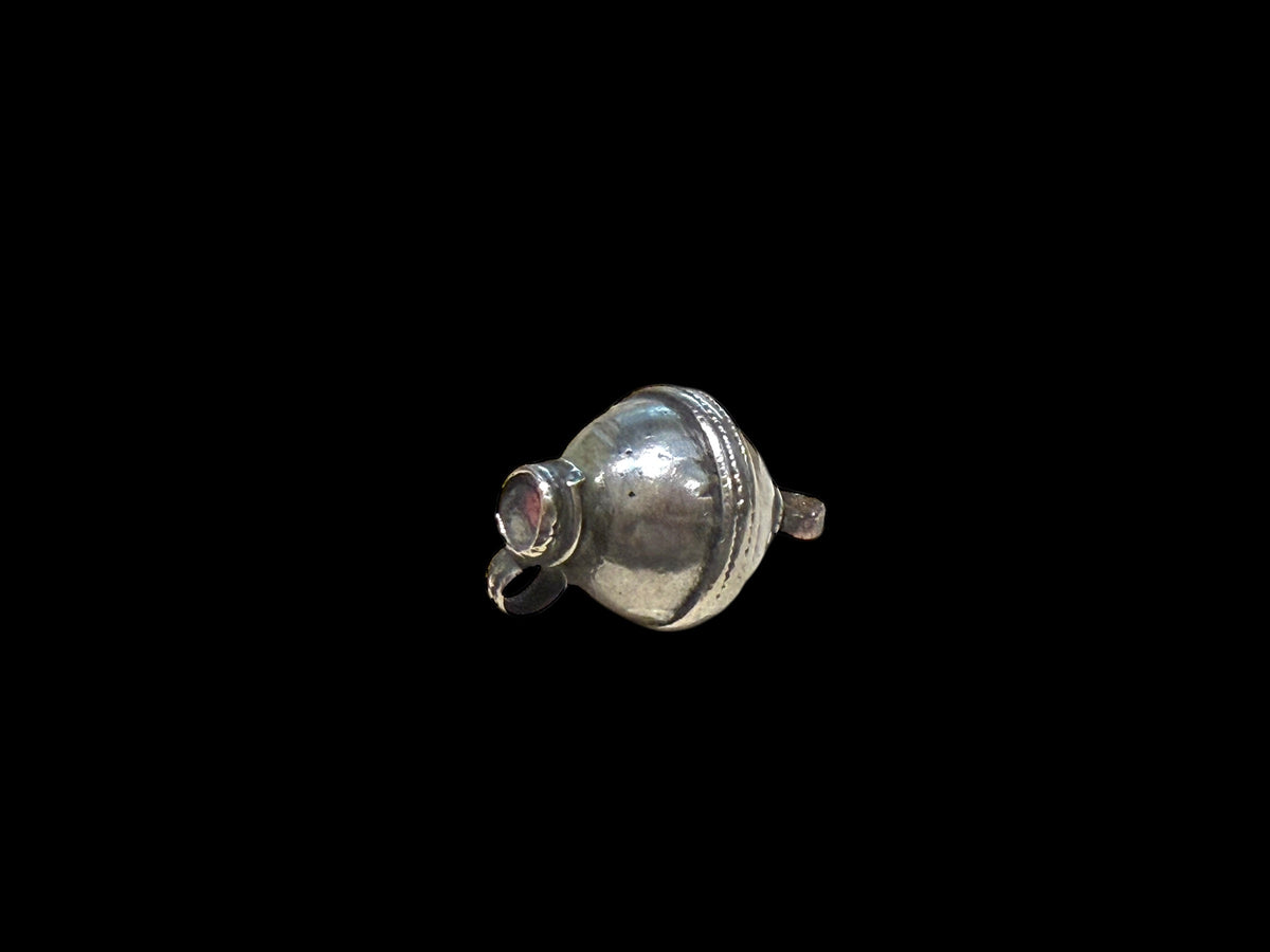 Unique tribal bead with two offset bails. Copper and silver, small glass bead set at one end. Early 20th C, northern India. Length 2.7 cm, diameter 1.7 cm.