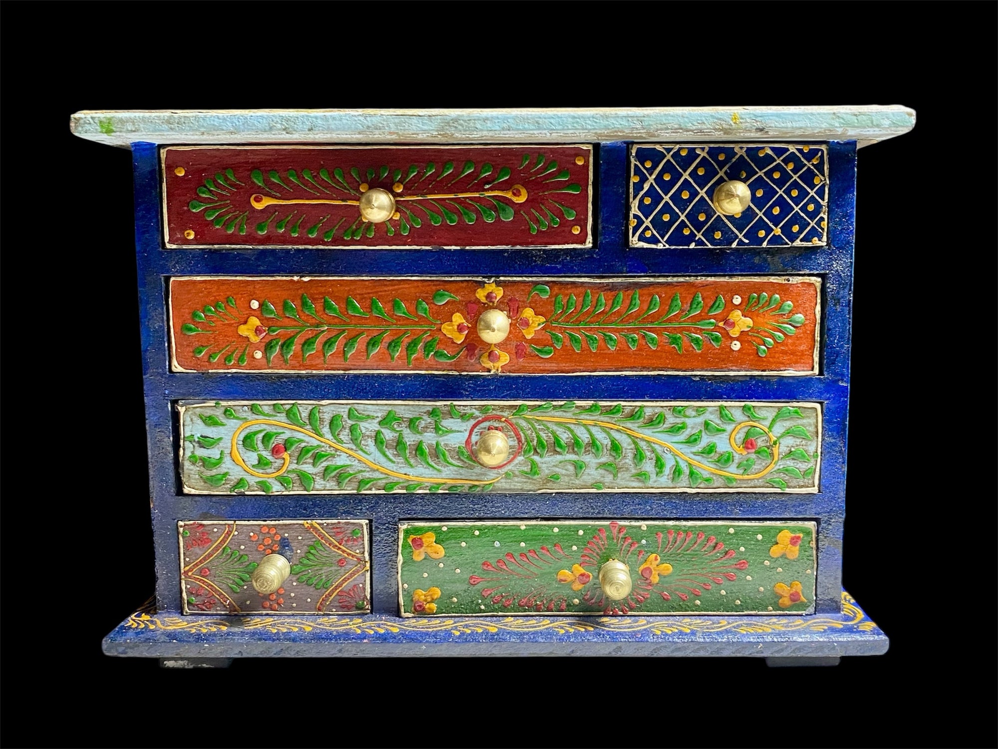 Hand painted chest of drawers features six drawers of varying sizes. Petite feet and polished brass knobs as handles. Small and compact, it is an ideal choice for storing a variety of items. Width 24 cm, depth 10 cm, height 17.5 cm
