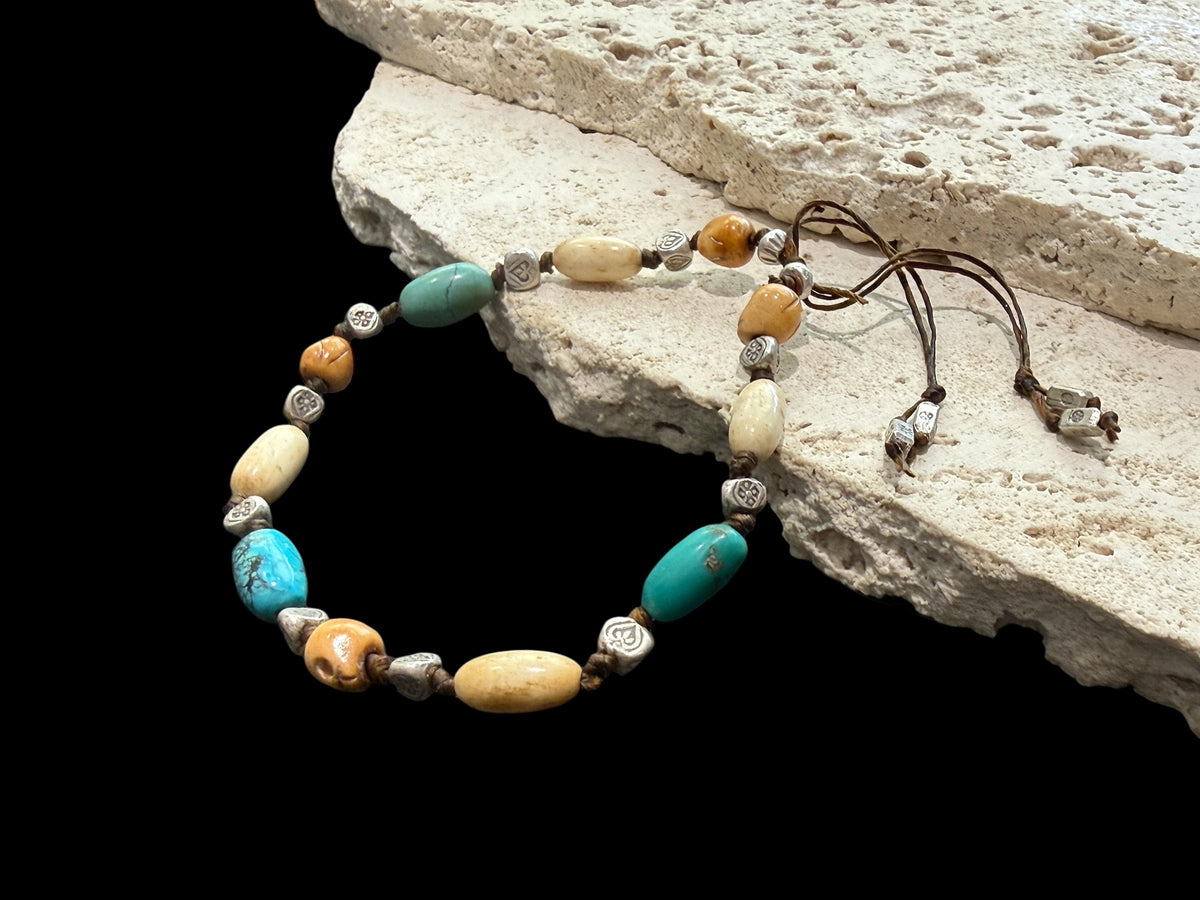 Yak bone skull beads, antique Tibetan turquoise, vintage Kachin bone and Karen hill tribe silver. Strung on sturdy waxed cord and adjustable. 20 cm or larger