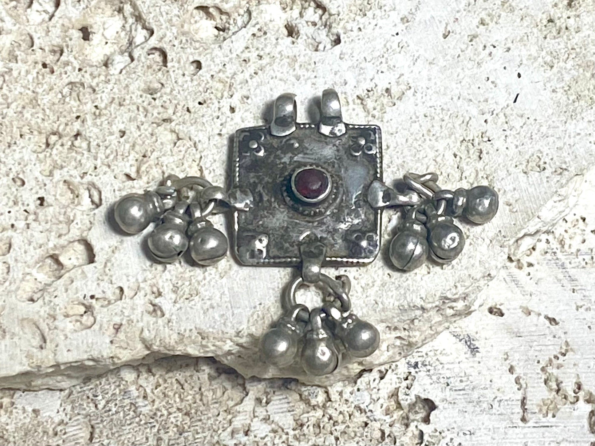 Square high grade silver amulet with dangles and gem decoration. Early to mid 19th century, Rajasthan. Note that the bails are very worn as shown. Height with dangles and bail 4 cm, width 4 cm