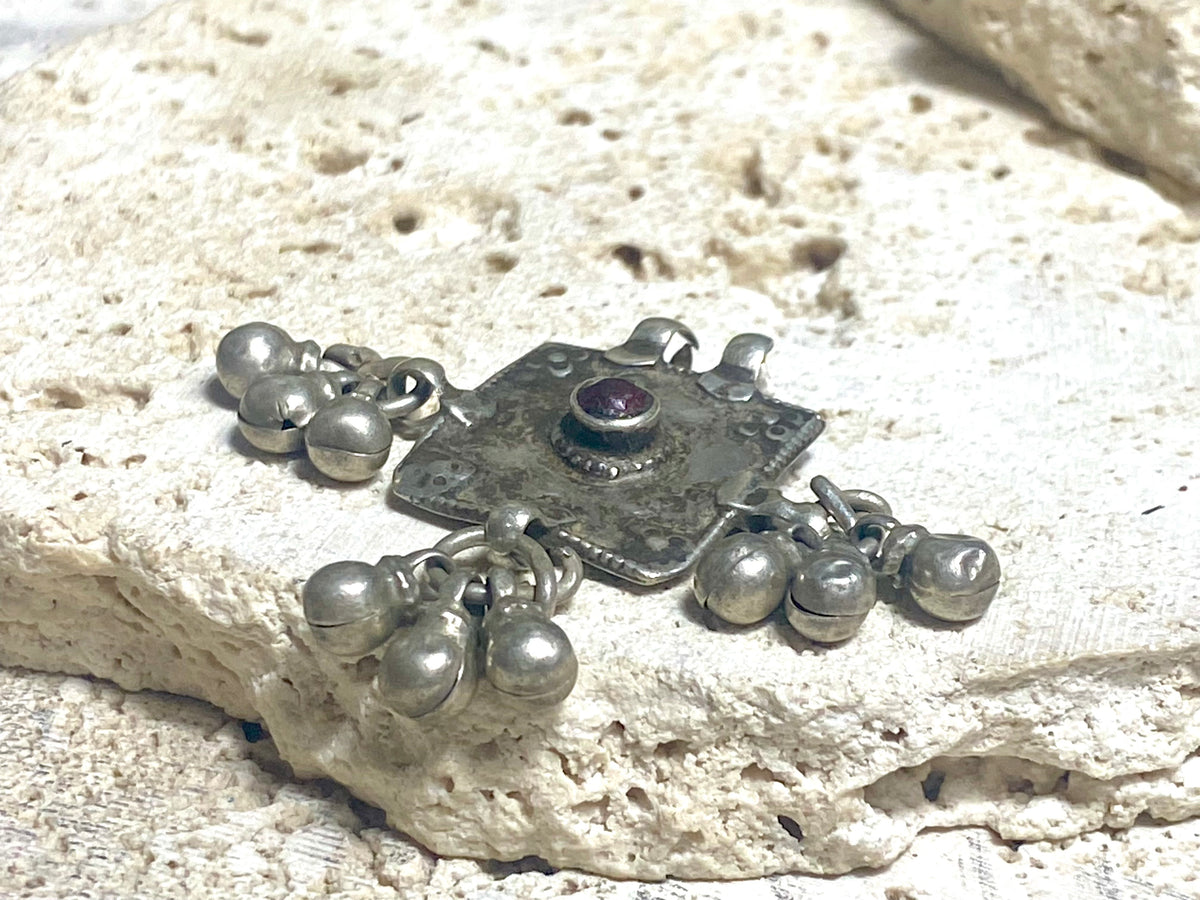 Square high grade silver amulet with dangles and gem decoration. Early to mid 19th century, Rajasthan. Note that the bails are very worn as shown. Height with dangles and bail 4 cm, width 4 cm