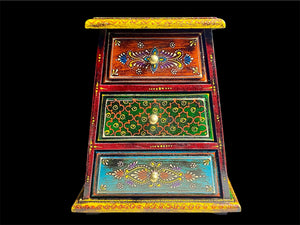 This intricately hand painted box features three drawers and small feet. Brass knobs as handles add a touch of elegance, perfect for holding everything from trinkets to jewellery. Width 21.5, depth 11.5 cm, height 24 cm
